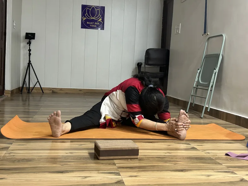Student in seated forward fold with props at Rajat Dua Yoga studio